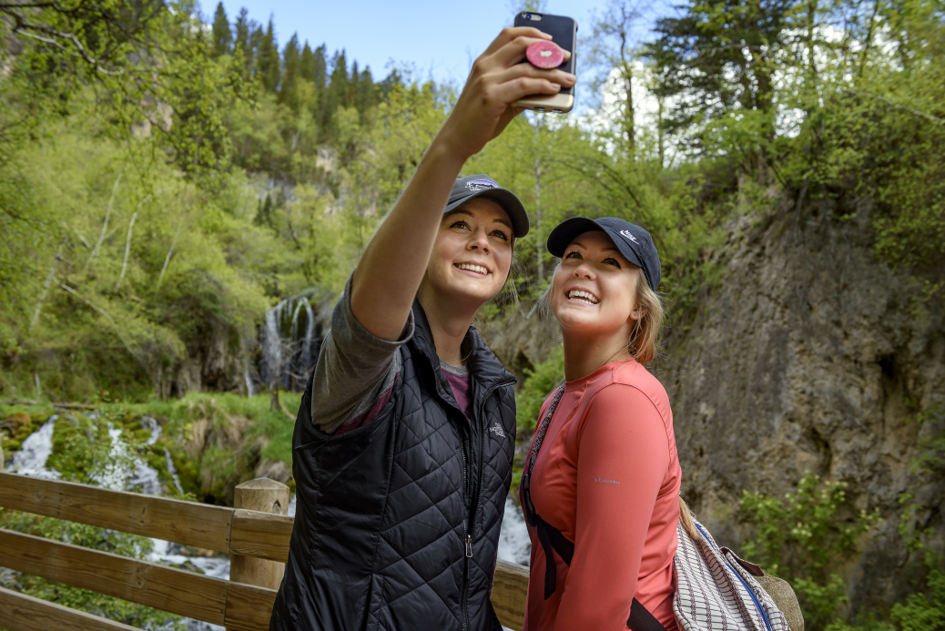 Two visitors taking a selfie in front of Roughlock Falls