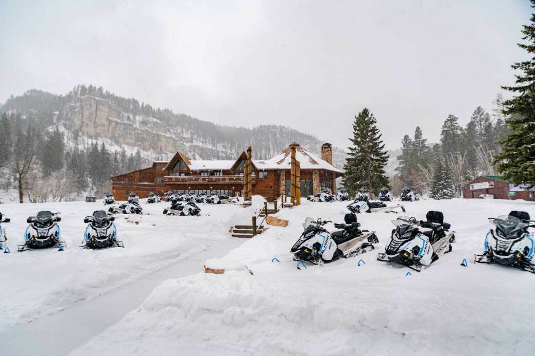 Spearfish Canyon Lodge in winter snowmobiles sitting on snow 