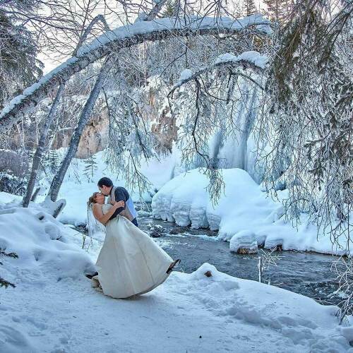 Winter Scene of Bride & Groom embracing in front of Spearfish Creek