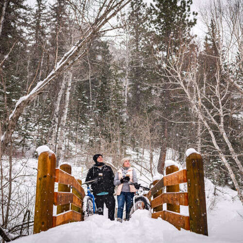 Couple standing on bridge in Spearfish Canyon in winter 