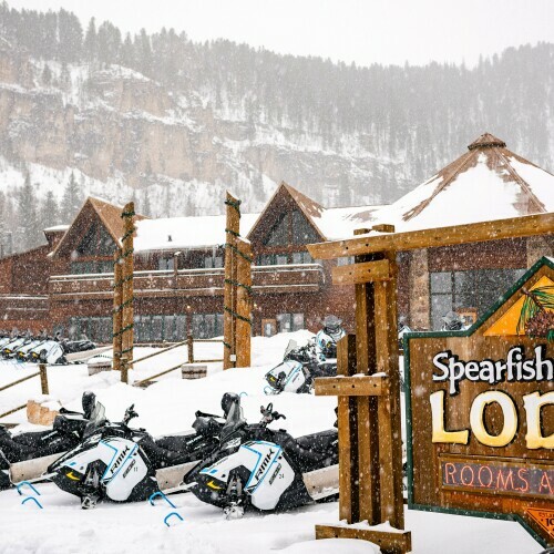 View of Spearfish Canyon with snowmobiles parked out front 