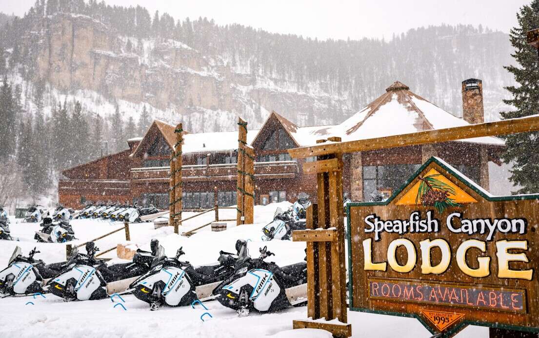 View of Spearfish Canyon with snowmobiles parked out front 